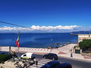 a street with cars parked in front of the ocean at Corso79 in Porto Santo Stefano