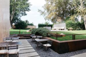 a patio area with chairs, tables, and benches at Riva Lofts Florence in Florence