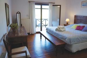 Villa Pefka في مدينة سكياثوس: غرفة نوم بسرير وطاولة ومكتب