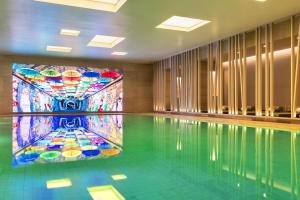 a swimming pool with a tile floor and a mosaic tile wall at Andaz Seoul Gangnam in Seoul