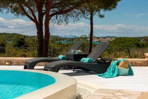 una piscina con 2 sillas y una mesa junto a una piscina en Villa Amethyst, en Porto Heli