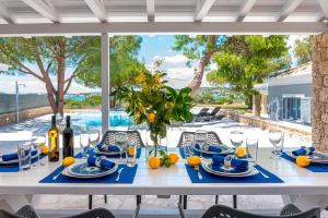 una mesa blanca con servilletas azules y naranjas. en Villa Amethyst, en Porto Heli