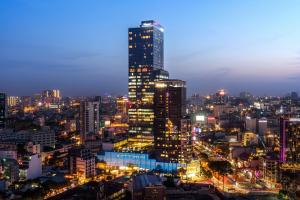 un perfil urbano por la noche con un rascacielos alto en Sedona Suites Ho Chi Minh City en Ho Chi Minh