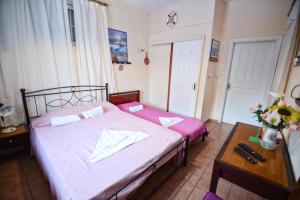 a small bedroom with a bed and a table at Ikaria Studios in Manganítis