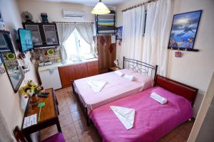 a bedroom with two beds and a table and a desk at Ikaria Studios in Manganítis