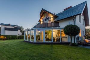 a house with large glass doors and a yard at Morze u Moni in Karwieńskie Błoto Pierwsze