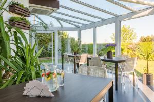a conservatory with tables and chairs and windows at Morze u Moni in Karwieńskie Błoto Pierwsze