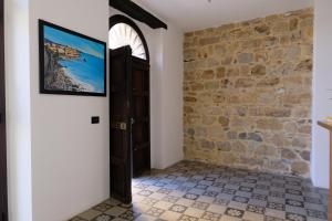 a hallway with a door and a stone wall at Il Miglio in Più in Castel di Tusa