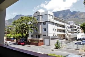 a large white building with mountains in the background at Table Mountain views, modern,lots of natural light, with parking in Cape Town