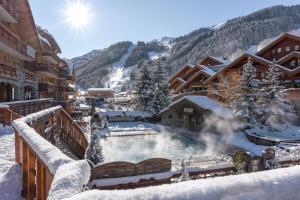 uma banheira de hidromassagem na neve num alojamento de turismo selvagem em Hotel Eterlou em Méribel