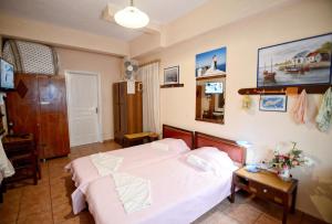 a bedroom with a white bed and a table at Ikaria Studios in Manganítis