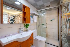 La salle de bains est pourvue d'un lavabo, de toilettes et d'une douche. dans l'établissement Yiwu Yuejia Business Hotel, à Yiwu