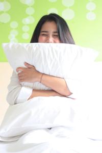Rúm í herbergi á Zest Jemursari by Swiss-Belhotel International