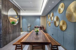 - une salle à manger avec une table, des chaises et des miroirs dans l'établissement Yiwu Yuejia Business Hotel, à Yiwu