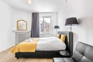 um quarto com uma cama e uma cadeira em Holiday house Villa Victoria em Diksmuide