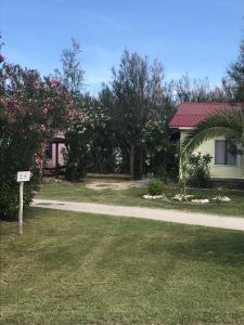 a house with a sign in the grass next to a road at Maronda Camping in Marina di Montenero