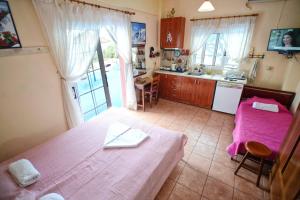 a bedroom with a bed and a kitchen with a sink at Ikaria Studios in Manganítis