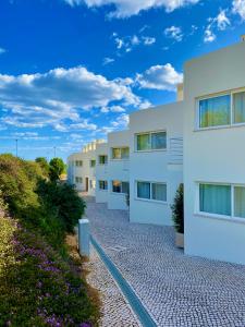 uma fila de edifícios de apartamentos brancos numa estrada de cascalho em Colina Verde Resort em Moncarapacho