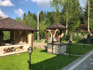 een tuinhuisje en een speeltuin in de tuin bij Олівія in Skhidnitsa