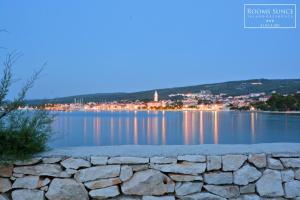 a view of the lake with a stone wall at ꕥ ROOMS SUNCE, Family choice, Best Panoramic view, Supetar Island Brac in Supetar +29 photos
