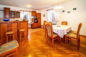 uma cozinha e sala de jantar com mesa e cadeiras em Apartmant Ivan em Malinska