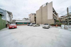 a parking lot with cars parked in front of a building at PiR2 House in Tainan