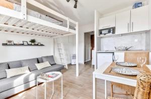 ein Wohnzimmer mit Sofa und Tisch in der Unterkunft Studio avec piscine, proche plages in Bandol