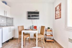 eine Küche mit einem weißen Tisch und Stühlen in einem Zimmer in der Unterkunft Studio avec piscine, proche plages in Bandol + 3 Fotos