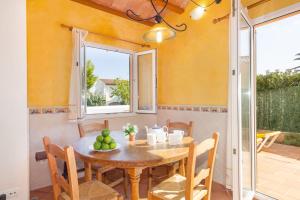 a dining room with a table and a window at Villa Blancala 502 in Cala Santandria