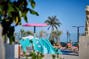 a pool with a water slide and an umbrella at Sea and Pool View apt Spa n Pools beach resort in Mamaia Sat/Năvodari
