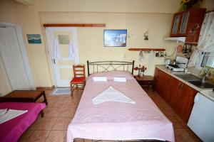 a bedroom with a bed with a pink blanket at Ikaria Studios in Manganítis