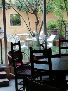 a table and chairs in a room with a tree at Casa Antiquary in Benitachell