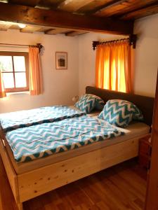 a bedroom with a bed with blue sheets and a window at Haus Moser in Altaussee