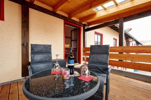 a table with a bottle of wine and glasses on a deck at Landgasthof Penn in Windorf