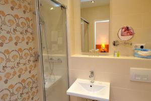 リンダウにあるホテル ヴィス ア ヴィスのシャワー、洗面台、鏡を備えたバスルーム +40枚の写真