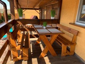 a wooden table and chairs on a balcony at Panorama Dofinovka in Nova Dofinivka