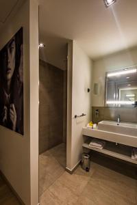 a bathroom with a sink and a large mirror at Wellings Parkhotel in Kamp-Lintfort