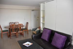 a living room with a couch and a table at Accommodation Sydney - Hyde Park Plaza 38 College St Sydney in Sydney
