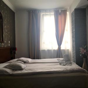 Schlafzimmer mit einem großen Bett und einem Fenster in der Unterkunft Európa Panzió in Mátészalka