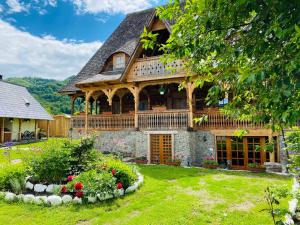 a large house with a gambrel roof at Casa Chira in Vişeu de Sus