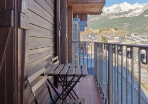 a bench on a balcony with a view of the mountains at Apartahotel Tres Quiñones in Sallent de Gállego