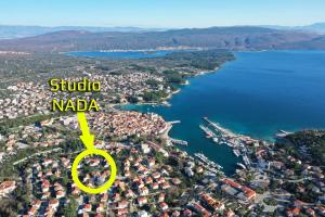 an aerial view of a city with a yellow arrow pointing to a lake at Studios Nada in Krk