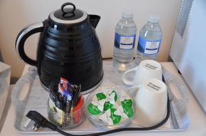einen Tisch mit einer Teekanne und 2 Flaschen Wasser in der Unterkunft Holly Lodge in Weston-super-Mare