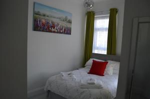 a bedroom with a bed with a red pillow on it at Holly Lodge in Weston-super-Mare