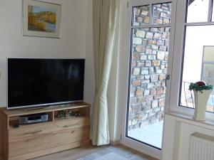 ein Wohnzimmer mit einem Flachbild-TV neben einem Fenster in der Unterkunft Ferien Apartment Melcher in Zeltingen-Rachtig