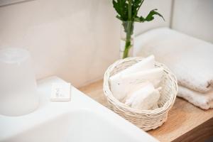 um cesto de lenços de papel sentado num balcão ao lado de um lavatório em Hotel Hanseport Hamburg em Hamburgo