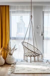 a hanging hammock in a room with a window at Blue Mandarin Garden Gates in Gdańsk