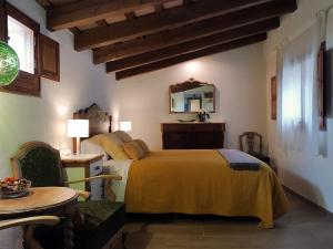 1 dormitorio con cama, mesa y espejo en Mas Gibert, en Sant Gregori