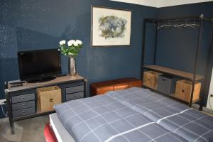 1 dormitorio con cama y vestidor con TV en Ferienwohnungen an der Liebesleite Anita Pratsch en Riedenburg