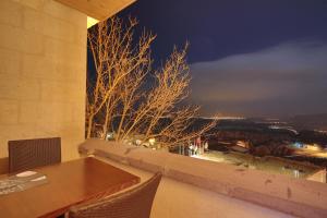 a dining room table with a view of a city at night at Aden Hotel Cappadocia in Uchisar